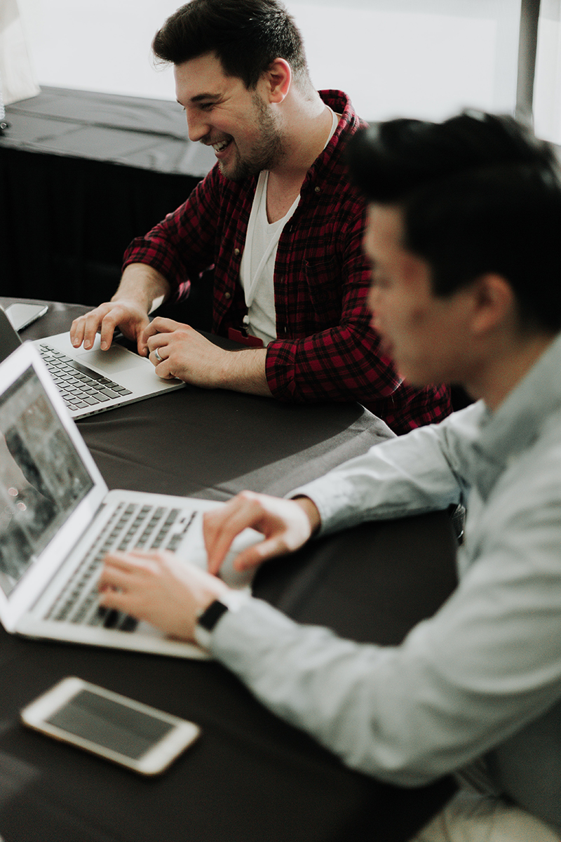 Two men working together on computers